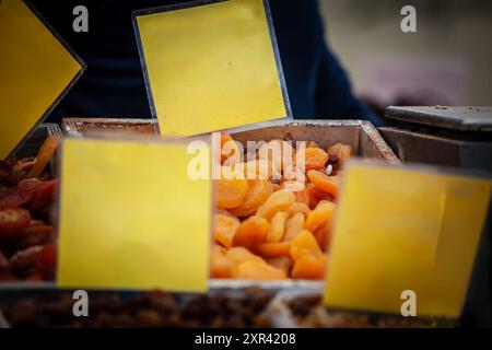 Questa fotografia ravvicinata mette in evidenza le albicocche essiccate esposte per la vendita in un mercato. L'immagine utilizza la messa a fuoco selettiva per attirare l'attenzione sul col vibrante Foto Stock