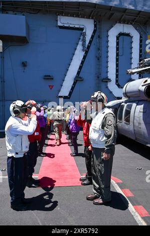 Vice Adm. John Wade, comandante, terza flotta degli Stati Uniti, esercitazione Rim of the Pacific (RIMPAC) 2024 Combined Task Force Commander, saluta i sideboys arcobaleno sul ponte di volo della portaerei classe Nimitz USS Carl Vinson (CVN 70) in quanto la nave partecipa alla fase di integrazione della forza del RIMPAC 2024, 20 luglio. Ventinove nazioni, 40 navi di superficie, tre sottomarini, 14 forze terrestri nazionali, più di 150 aerei e 25.000 personale partecipano al RIMPAC nelle e intorno alle isole Hawaii, dal giugno 27 al agosto 1. Il RIMPAC, il più grande esercizio marittimo internazionale al mondo, offre una t Foto Stock