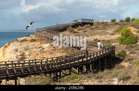 Donna anziana che esercita in riva al mare sulla passerella Algar Seco a Carvoeiro, Algarve, Portogallo Foto Stock