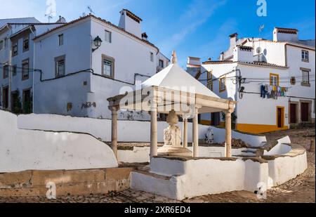 Vista simmetrica di Fonte da Vila, una fontana medievale nella città di Castelo de vide in Portogallo Foto Stock