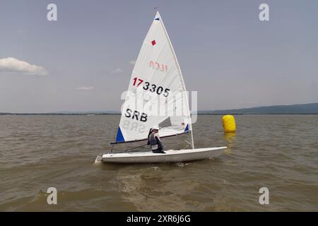 Golubac, Serbia, 9 giugno 2024: Una ragazza adolescente prende parte a una regata a vela di classe laser sul Danubio. Foto Stock