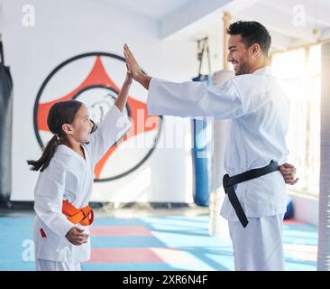 Arti marziali, karate e high five in studio per fitness, insegnamento e rispetto con stretta di mano o grazie. Sensei, studentessa e celebrazione come persone Foto Stock