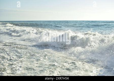 Grandi onde nel mare. Bellissimo mare con spruzzi sotto la luce del sole mattutino. Foto Stock