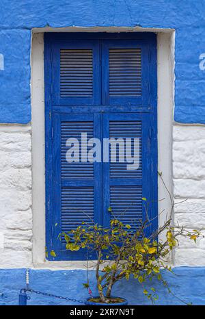 Finestra bianca e blu di una casa storica nella medina del centro storico di Asilah in Marocco Foto Stock