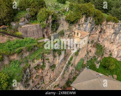 Vista aerea della chiesa di Santa Maria de Montgrony, incastonata nella roccia e nelle scogliere della catena montuosa (Ripollès, Girona, Catalogna, Spagna) Foto Stock