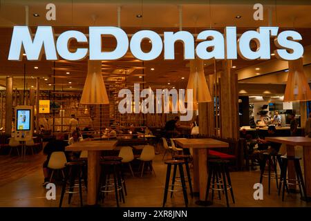 Vista interna del ristorante McDonald's con arredamento contemporaneo in legno. Moderno ristorante fast food interno con chioschi self service. Copenhagen, Denmar Foto Stock