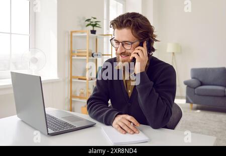 Un uomo d'affari gioioso è soddisfatto di una conversazione di lavoro piacevole e di successo sul telefono cellulare. Foto Stock