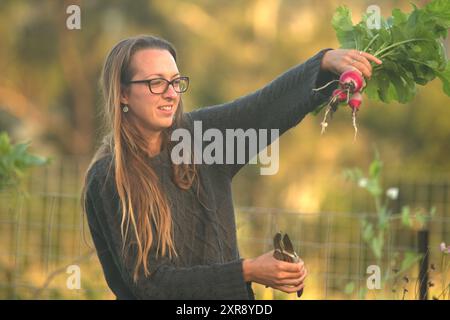 Donna che tiene il cimelio radiale in un giardino Foto Stock