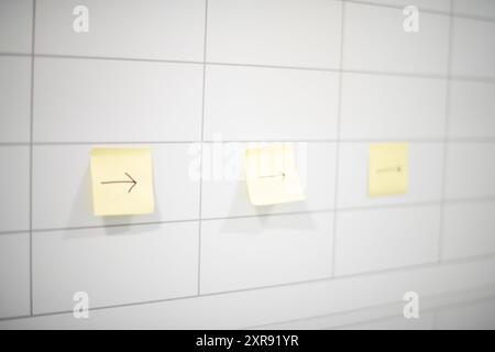 Tre note adesive gialle post-it con frecce rivolte verso destra Foto Stock