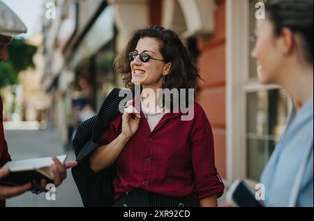 Giovani soci d'affari che conversano all'aperto in una giornata intensa Foto Stock