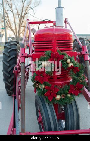 Trattore rosso decorato con una corona di Natale Foto Stock