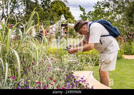 Un visitatore scatta foto al RHS Hampton Court Palace Garden Festival (The Hampton Court Flower Show), Regno Unito Foto Stock