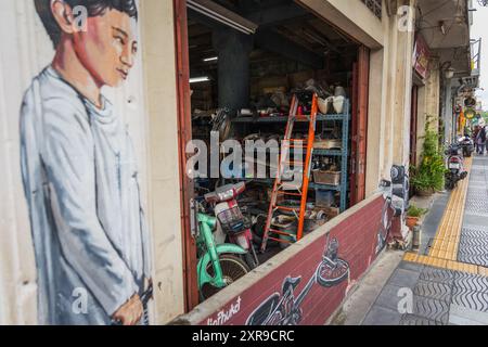 Motocicletta in officina. Vecchio negozio con biciclette e scooter rotti per la riparazione. Servizi e riparazione di motociclette. Thailandia Phuket luglio 18,2024 Foto Stock