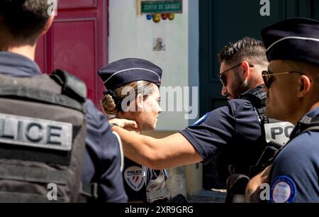 8 agosto 2024. Agente di polizia che tiene il collo di un collega vicino a Montmatre, Parigi, Francia. Foto Stock