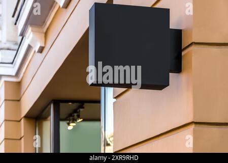 Mockup vuoto di cartellone nero del ristorante Street Square sulla parete gialla Foto Stock