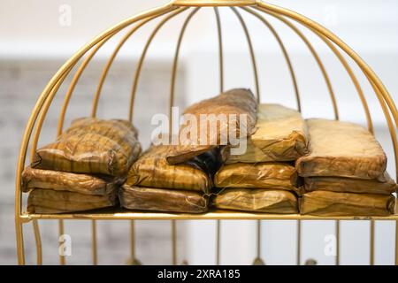 Burasak, un alimento tradizionale dove il riso viene cotto con latte di cocco, cotto al vapore e avvolto in foglie di banana. Foto Stock