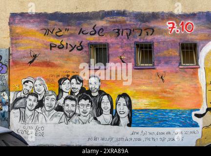 L'ultimo massacro del partito Dance Nova il 7 ottobre 2023 colorati graffiti politici su un muro nel quartiere Kiryat Hamelacha, Tel Aviv, Israele Foto Stock