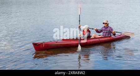 Padre insegna al figlio il kayak in riva al mare con pagaie per kayak in riva al mare, canoa, nautica nel Mar Baltico durante le vacanze estive in famiglia Foto Stock