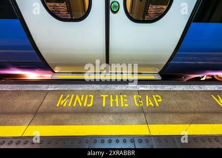 Stazione della metropolitana di Londra con il cartello Mind the Gap, motto sulla piattaforma della stazione ferroviaria. Un motto iconico di Londra, catchphrase. Niente persone Foto Stock