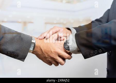 Uomini d'affari che stringono la mano. Concetto di cooperazione e di contrattazione nel settore delle imprese. Immagine a doppia esposizione. Un mix di immagini che costruisce città e uomo d'affari è S. Foto Stock