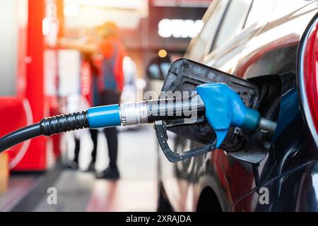 Rifornire di carburante le auto alla pompa carburante. Il conducente deve fare il pieno di carburante e pompare la benzina dell'auto con carburante alla stazione di rifornimento. Rifornimento di auto presso una stazione di servizio. OI Foto Stock