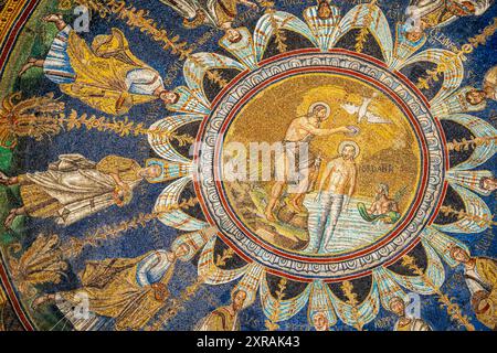 Primo piano sul mosaico religioso che decora il soffitto della basilica cattolica di Ravenna, mostrando un gruppo di santi intorno a Gesù battezzato Foto Stock