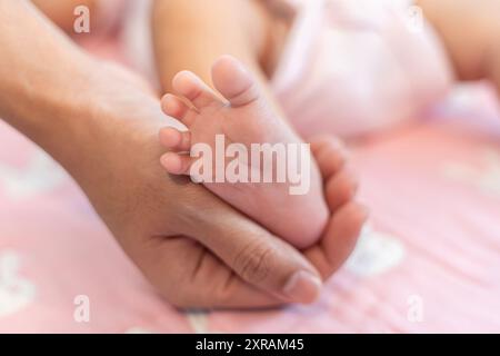 Piedi del bambino nelle mani di madre. Piccolo Neonato con i piedi sul sagomato femmina closeup mani. La mamma e il suo bambino. Happy Family concept. Bella imag concettuale Foto Stock