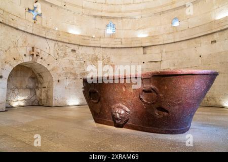 Antica vasca da bagno romana scolpita in marmo rosso esposta all'interno dell'antica chiesa di Ravenna Foto Stock
