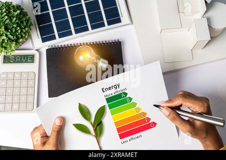 Audit energetico della casa. Concetto di efficienza energetica con diagramma di livello grafico di efficienza energetica da tavolo con calcolatrice a diagramma casa pannelli solari. Businessma Foto Stock