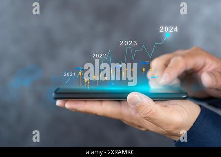Pianificazione e strategie per il progresso o il successo dell'attività in borsa, successo nel 2024. Uomo d'affari che mostra un crescente stock di ologrammi virtuali Foto Stock