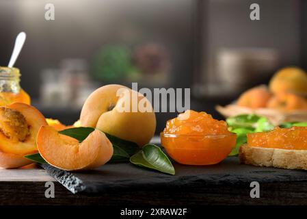 Dettagli di pesca e marmellata di frutta con una cucina scura sullo sfondo. Vista frontale. Foto Stock