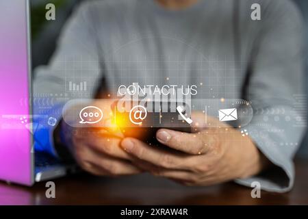 Contattaci o contatta il servizio di assistenza clienti. Uomo d'affari che utilizza un laptop e tocca le icone dei contatti sullo schermo virtuale ( e-mail, indirizzo, live Foto Stock