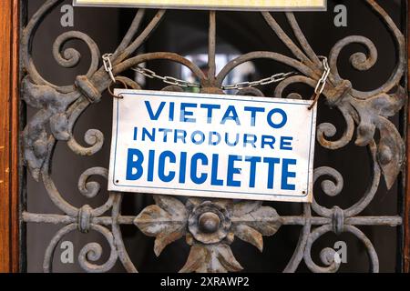 Vecchio cartello in italiano con il testo "non sono ammesse biciclette" Foto Stock