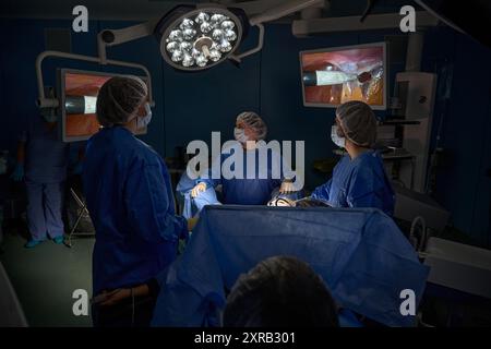 Chirurghi che eseguono interventi chirurgici complessi in sala operatoria Foto Stock