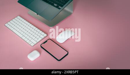 Laptop e smartphone. Vista dall'alto composizione geometrica su sfondo rosa. Modello con schermo vuoto. Foto Stock