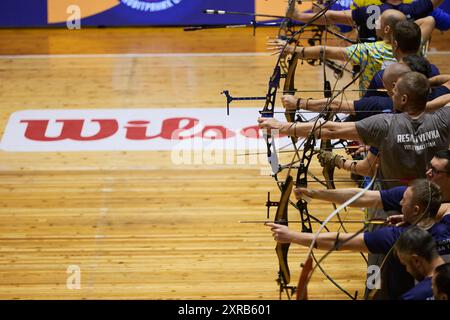 Gruppo di arcieri con archi che puntano i bersagli durante la gara di tiro con l'arco arst. Kiev - 14 dicembre 2023 Foto Stock