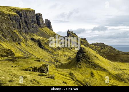 Uno splendido paesaggio della frana di Quiraing sull'isola di Skye, in Scozia, con aspre scogliere e colline ondulate sotto un cielo nuvoloso Foto Stock