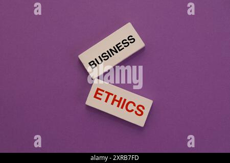 Due blocchi di legno con scritto "business" e "Ethics", che suggeriscono l'importanza delle pratiche commerciali etiche. Foto Stock