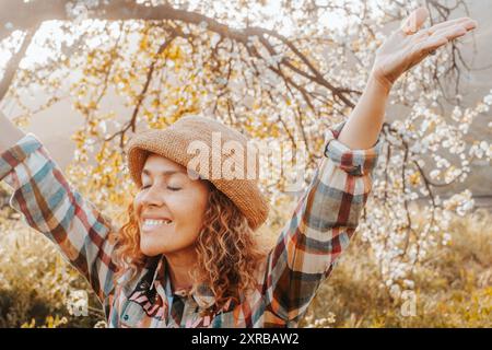 Primavera. Benvenuto nell'immagine del concetto di primavera con una felice donna che solleva le braccia e chiude gli occhi che abbraccia e ama la natura. Concetto di attività ricreative all'aperto. Giornata di libertà e successo Foto Stock