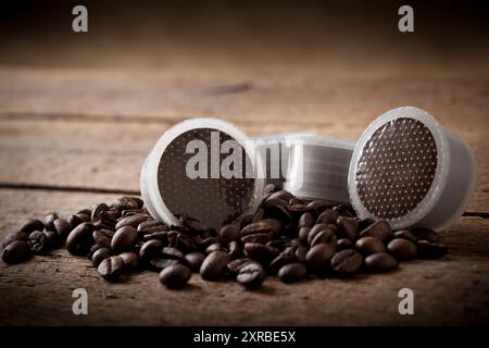 I chicchi di caffè con cialde su un tavolo di legno. Foto Stock