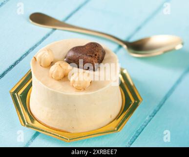 Piccola torta di nocciole e cioccolato fondente cuore blu sul tavolo di legno. Foto Stock