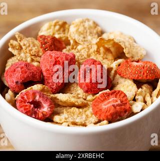 Colazione sana, cornflakes e fragole con latte, primo piano. Foto Stock