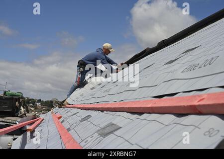 Lavori di costruzione di tetti, Man on roof Installing Roofing membrane, UK Foto Stock