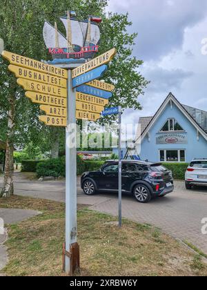 Un cartello decorativo all'angolo di una strada mostra le varie direzioni per raggiungere le località turistiche di Prerow, Fischland Darß, Meclemburgo-Vorpommern, Germania Foto Stock