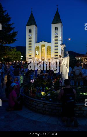 La gente prega intorno alla statua della Regina della Pace vicino alla Chiesa di San Giacomo a Medjugorje, Bosnia-Erzegovina. Foto Stock