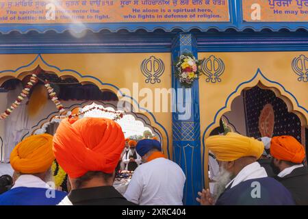 Inghilterra, Kent, Gravesend, il Guru Nanak Darbar Gurdwara, l'annuale Vaisakhi, alias Baisakhi Festival, che si tiene il 13 aprile, i partecipanti alla sfilata pregano davanti al Sacro Carro Carro Foto Stock