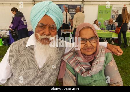 Inghilterra, Kent, Gravesend, il Guru Nanak Darbar Gurdwara, l'annuale Vaisakhi, alias Baisakhi Festival, che si tiene il 13 aprile, anziana coppia Sikh vestita con il colorato costume tradizionale Sikh Foto Stock
