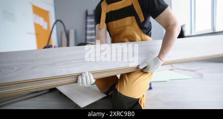 Un riparatore in uniforme tiene in primo piano i pannelli laminati Foto Stock