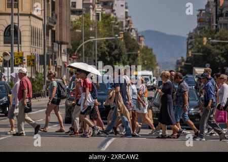 Barcellona, Spagna. 09 agosto 2024. Un grande gruppo di persone ha visto attraversare la via Aragón in una giornata calda nel centro di Barcellona. Barcellona soffre ancora una volta di un'ondata di caldo con temperature che raggiungono i 40 gradi Celsius sull'asfalto del centro città. (Foto di Paco Freire/SOPA Images/Sipa USA) credito: SIPA USA/Alamy Live News Foto Stock