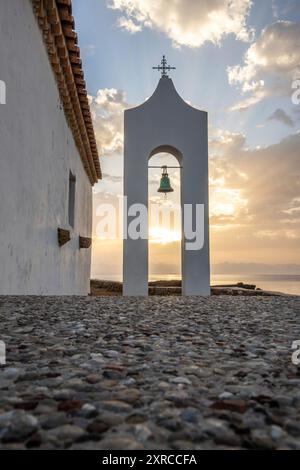 Piccola chiesa bianca in tipico stile architettonico greco, situata su una roccia lavica, circondata dal Mar Mediterraneo, Cappella di Agios Nikolaos all'alba, Zante, Isole Ionie, Grecia Foto Stock